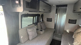 RV rental interior: A compact and functional living space with upholstered seating, storage, and shower access.