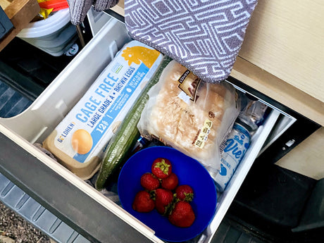 Packed for adventure in an **rv rental**! Eggs, bread, strawberries, cucumber, and Belle Vie in the compact fridge drawer.