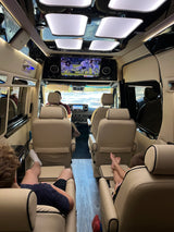 Plush interior of an **RV rental** with reclining seats & TV. Ideal mobile lounge for comfortable road trips & family fun.
