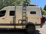 This adventure-ready 4x4 camper van, ideal for rv rental, features a roof rack, ladder, and off-road tires for exploring.