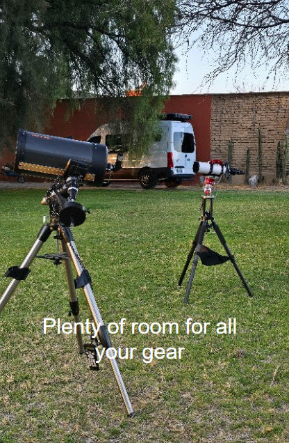 Two telescopes are set up for stargazing in a grassy yard, with a white RV rental parked behind. Ideal for astronomy camping.