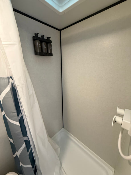 RV rental shower with convenient wall-mounted shampoo, conditioner, and body wash dispensers.