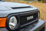 Front view of a wet grey Toyota FJ Cruiser. A rugged vehicle, great for pairing with your rv rental adventure.