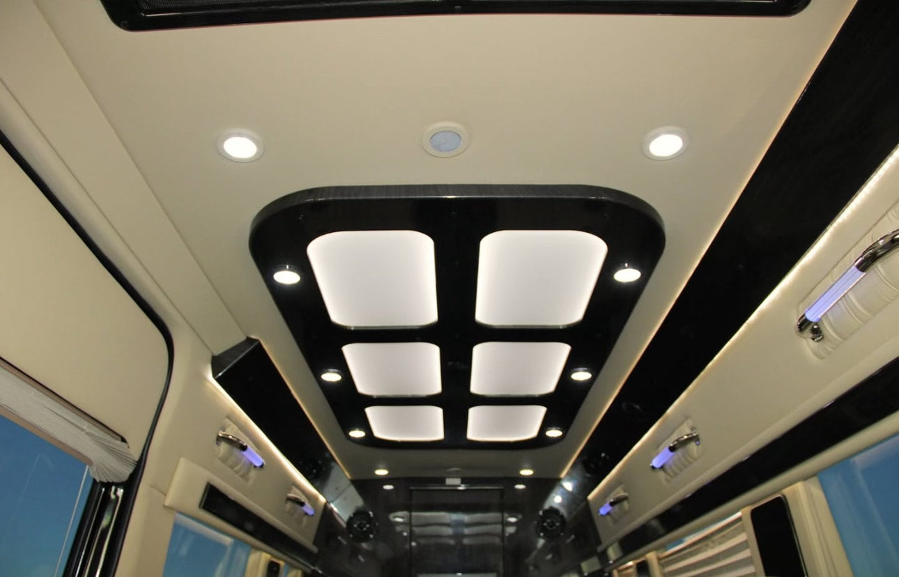 Luxury rv rental interior showcasing a modern ceiling design with bright square panels, recessed spotlights, and subtle blue ambient lighting. — photo 9