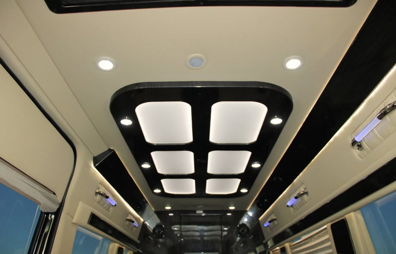 Luxury rv rental interior showcasing a modern ceiling design with bright square panels, recessed spotlights, and subtle blue ambient lighting. — photo 9