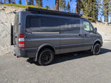 Gray Mercedes Sprinter camper van, an RV rental, ready for exploration with off-road tires and rooftop awning.