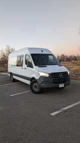 White Mercedes Sprinter camper van for rv rental, parked at dusk. Perfect for adventure.