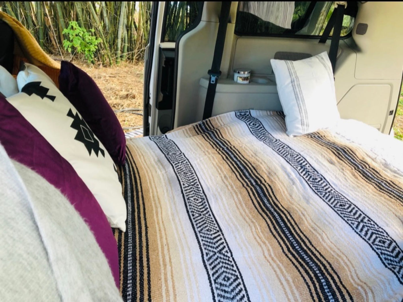  featuring a comfortable bed with decorative pillows & striped blankets — photo 2