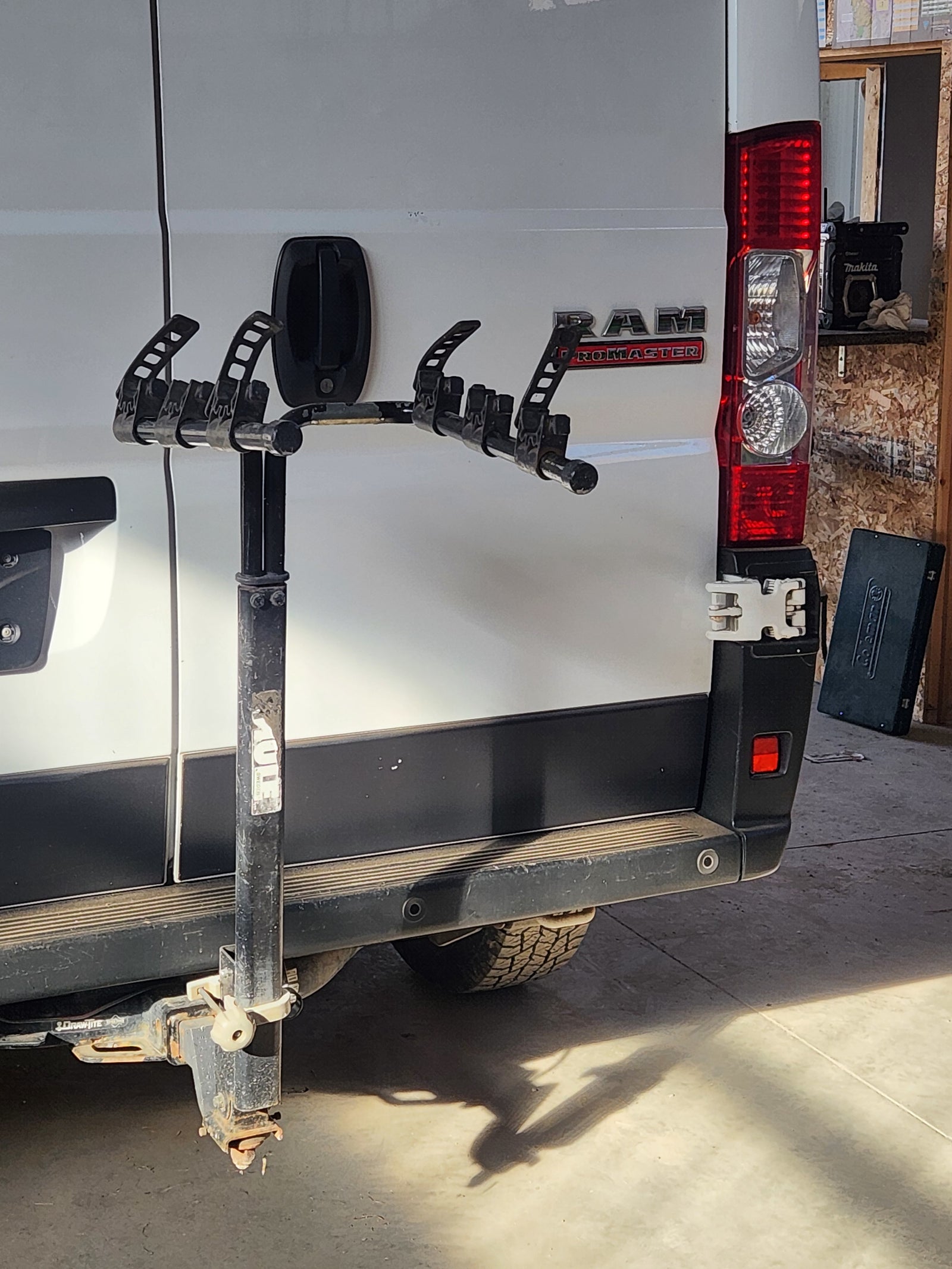 Rear view of a white Ram ProMaster **rv rental**, equipped with a Thule bike rack on its hitch. Ideal for outdoor adventures.