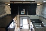 Explore this RV rental's interior: a compact pop-up camper kitchen with sink, stovetop, fridge, and storage.