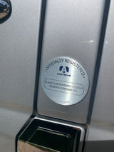 Officially registered Airstream RV rental plaque. "Slavic's Interstate Coach" and VIN visible on the brushed metal surface.