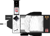 Overhead view of an RV rental interior: bed, counter with laptop, mini-fridge with snacks, and shoes. Compact mobile living.