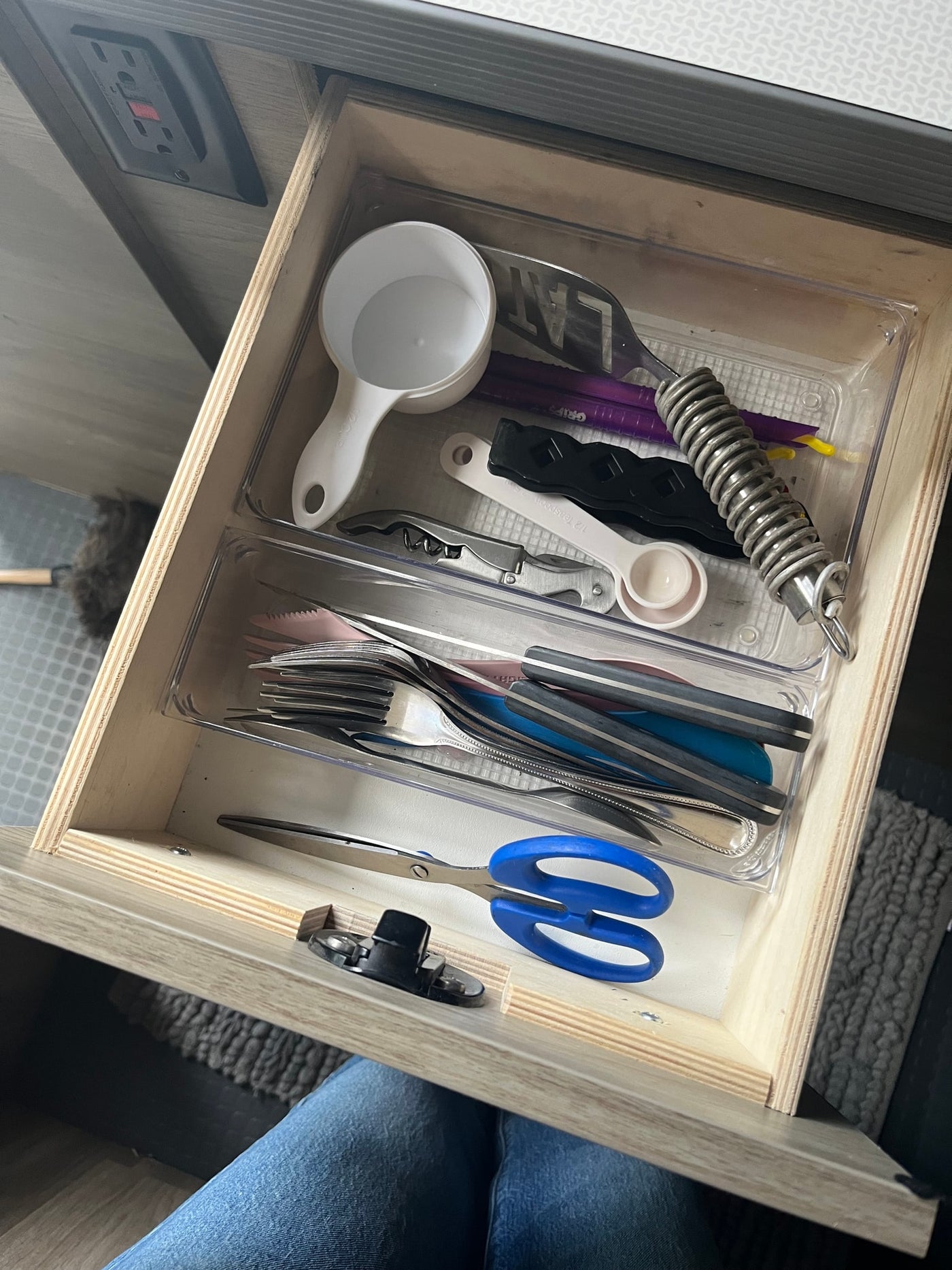 Inside an RV rental, a compact kitchen drawer is organized with cooking utensils, flatware, and essential tools like scissors. — photo 14