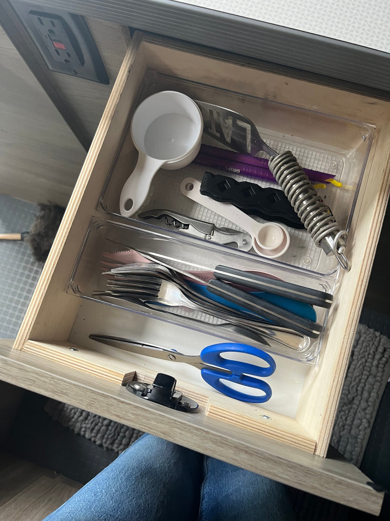 Inside an RV rental, a compact kitchen drawer is organized with cooking utensils, flatware, and essential tools like scissors. — photo 14