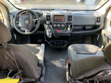 Spacious RV rental front cabin showcasing the steering wheel, detailed dashboard, and two dark gray front seats.