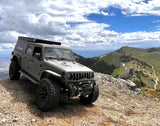 Overland Jeep Gladiator on a mountain peak, offering rugged adventure views. Explore RV rental for your next epic journey!