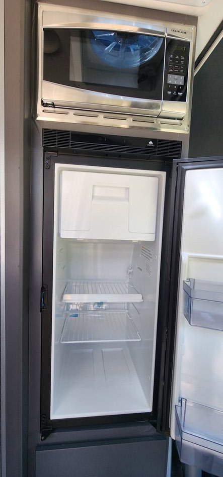 Clean RV rental kitchen: Norcold fridge/freezer & Contour microwave, ready for your trip.