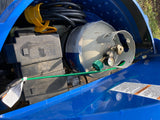 RV rental compartment showing a battery box, propane tank with gauge, and coiled power cord, essential for travel.