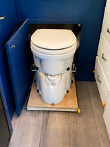 This RV rental features a pull-out composting toilet in a blue cabinet, optimizing space for comfortable mobile living.
