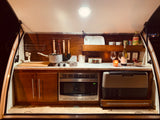 RV rental: Compact camper kitchen with stove, microwave, and cooler. Ready for your adventure!