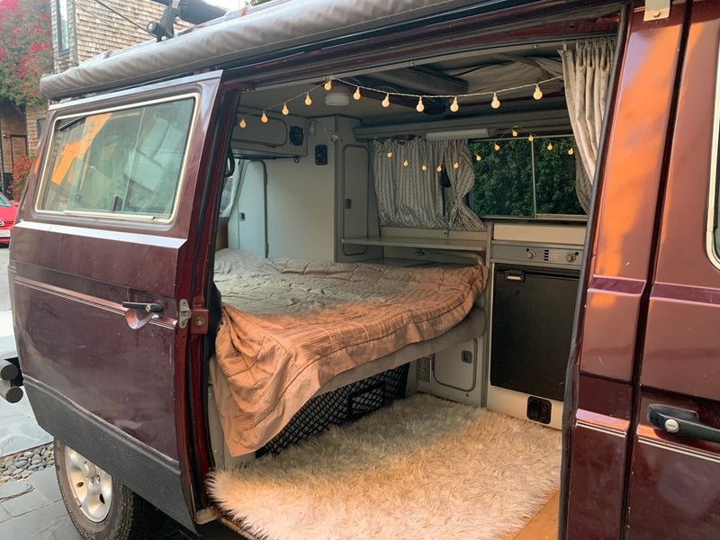  is ready for a desert RV rental adventure.|Dark maroon RV rental van on a white sand path — photo 6