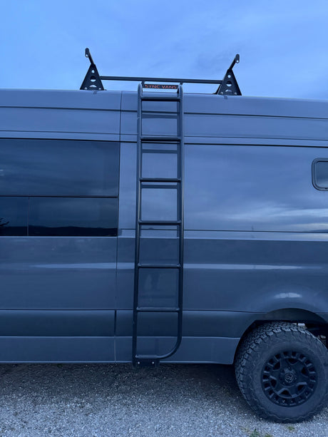 Grey Sync Vans RV rental with a side ladder, roof rack, and rugged tires, ready for your next adventure.