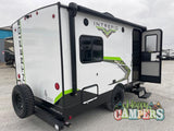 This white Intrepid travel trailer with green accents, featuring an open door and rear spare tire, ready for your next RV rental camping trip.