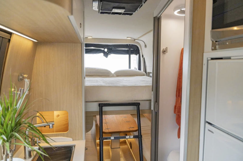  offering a scenic forest view – ideal for remote work.|Man works on laptop in a stylish RV rental — photo 6