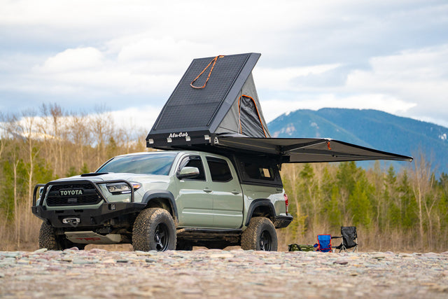 Overlanding Toyota Tacoma with open rooftop tent & awning. Experience remote camping, a great alternative to an rv rental.