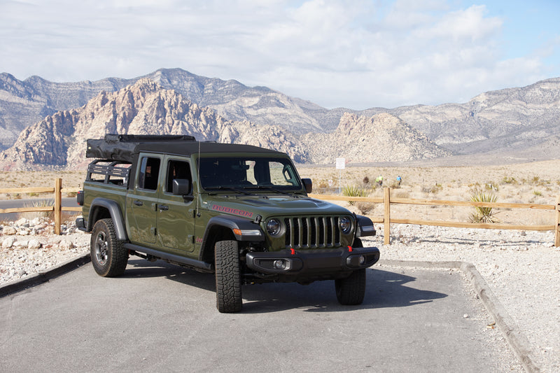 Green Jeep Gladiator with camping gear in desert mountains. An ideal RV rental for outdoor adventures. — photo 3