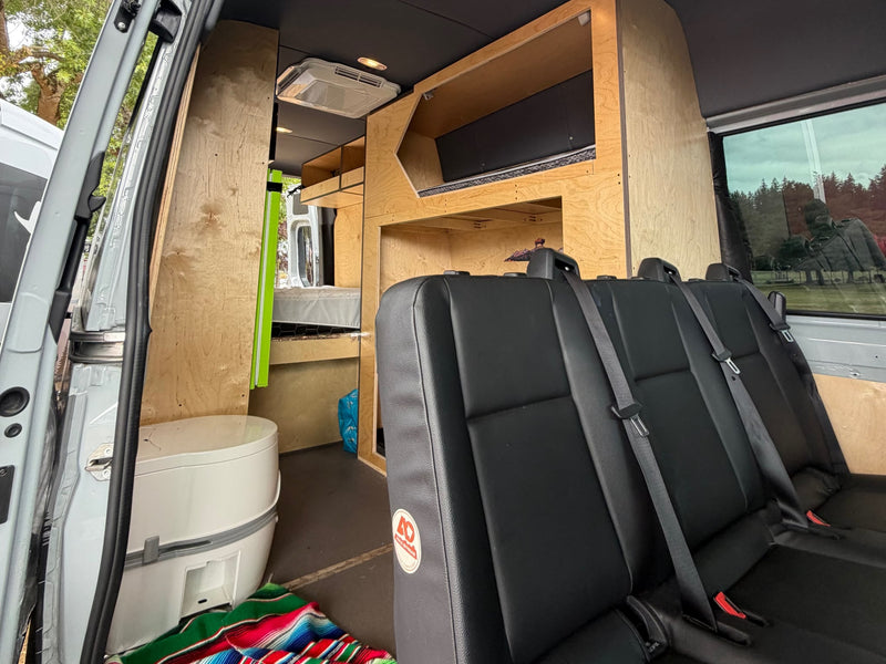  showcasing a rugged mountain and topographic line design.|**Custom-built camper van interior featuring a cozy bed — photo 6