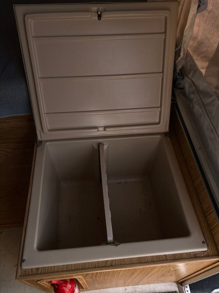 View inside an RV rental's built-in cooler/storage, featuring dual compartments for easy organization.
