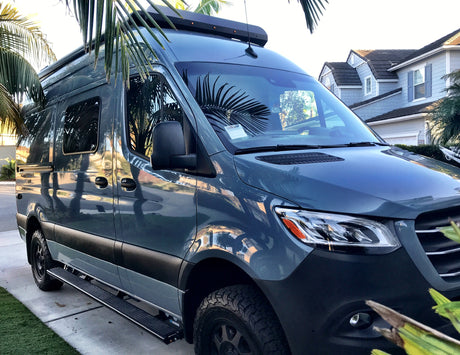 Stylish blue Mercedes Sprinter camper van on a driveway, great for RV rental adventures!