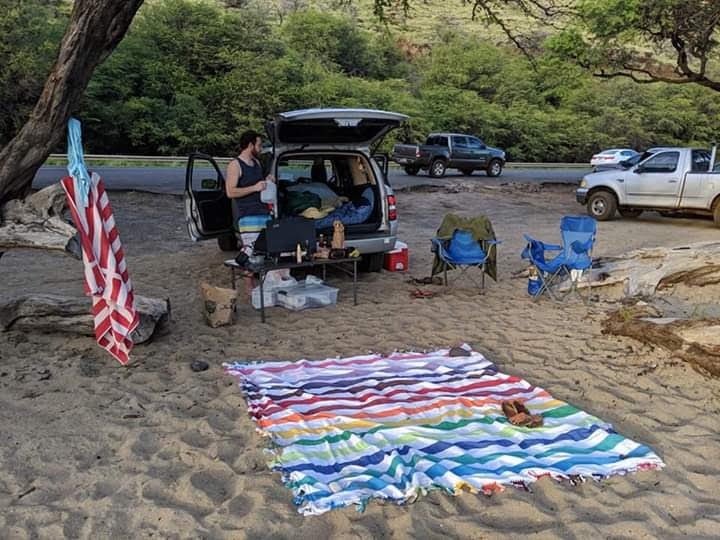 Car camping beside the road on sand. A person unpacks — photo 1