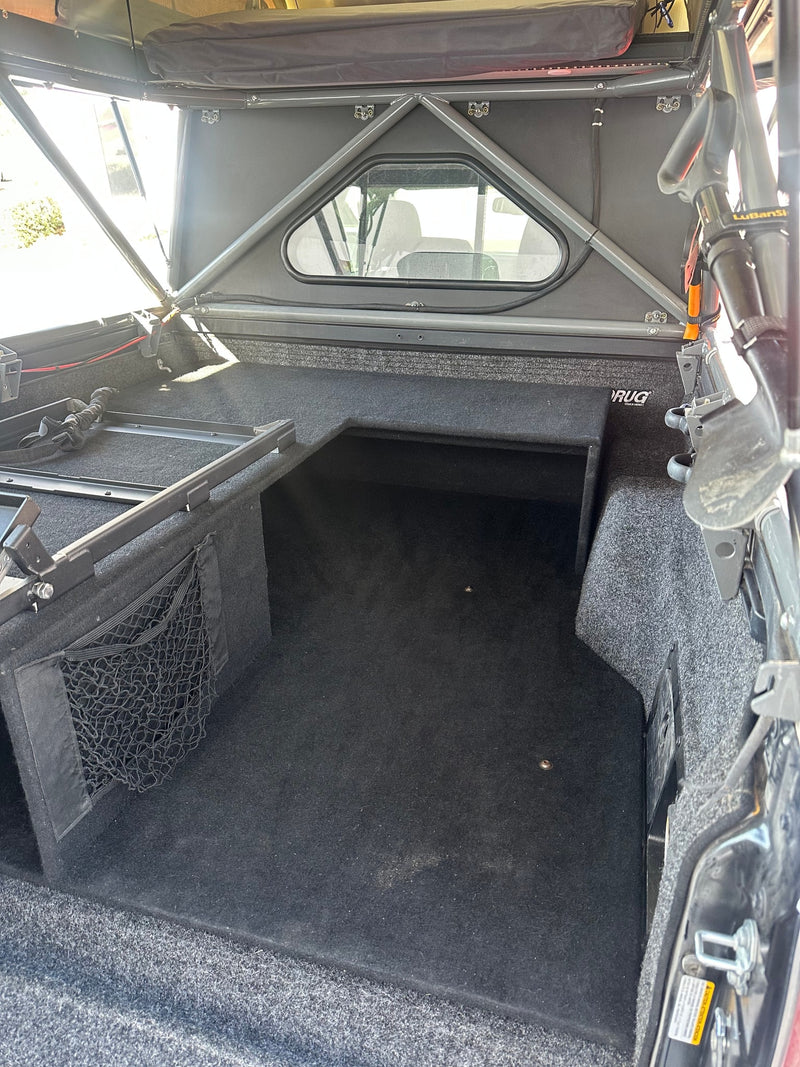 RV rental featuring a custom truck bed with carpeted storage, built-in compartments, and a drawer system for adventure gear. — photo 17