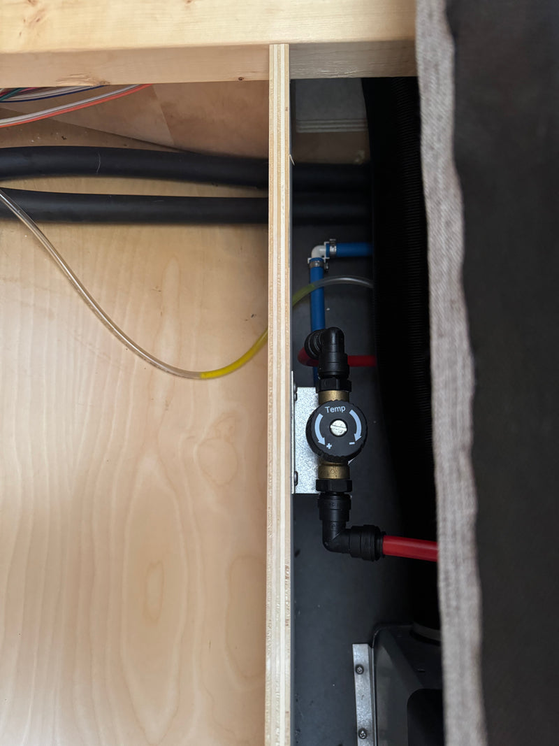 Inside an rv rental, a 'Temp' dial controls water heater output, with red and blue PEX plumbing lines visible for hot water comfort. — photo 18