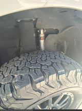 An RV rental's robust BFGoodrich T/A all-terrain tire and wheel, with a Fox Performance Series shock absorber visible in the wheel well.
