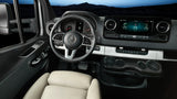 Inside a modern Mercedes-Benz Sprinter RV rental: driver's cockpit with navigation screen, steering wheel, and sleek controls.