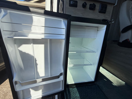 Wanda's refrigerator ready for your adventure. Features interior and door shelves which can be accessed from inside or outside the van.