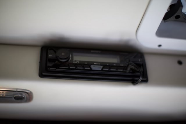 A mounted Sony car stereo with AUX cable plugged in provides entertainment for an RV rental.