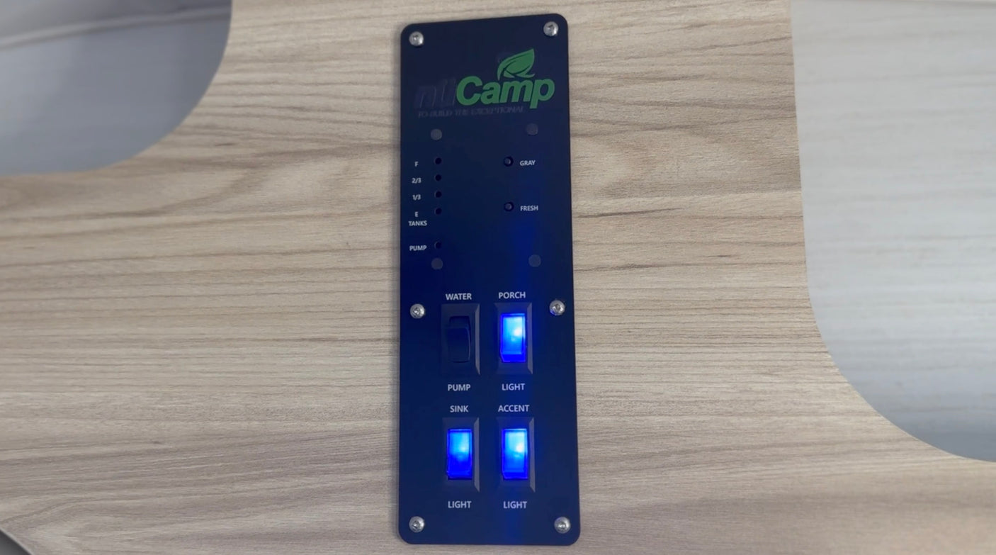 nuCamp RV rental control panel shows water pump, light switches, and tank level indicators.