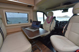 Remote work from your RV rental: a comfy interior with laptop, ocean, and island views, plus a welcoming lei.