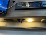 RV rental interior featuring a Roku TV, Jensen stereo, AC/USB outlets, speaker, and light for onboard entertainment and charging.