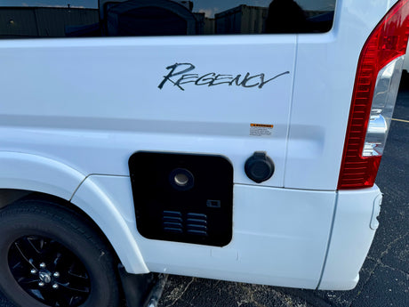 A white Regency RV rental side: 30A Park Power inlet, warning label, and appliance vent, detailed for accessibility.