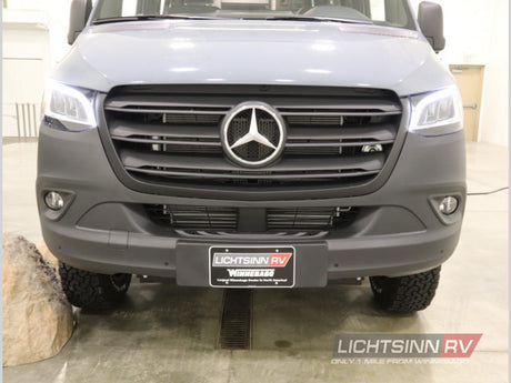 Front view of a rugged grey Mercedes-Benz Sprinter RV, with off-road tires. Perfect for your next rv rental adventure.
