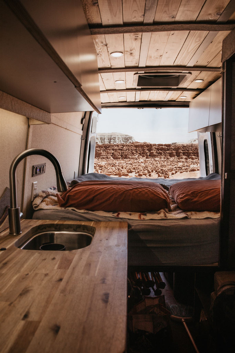  with coffee & breakfast items on the counter.|RV rental: Inside a modern camper van showing kitchen — photo 19