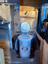 RV rental: Modern camper van interior featuring an open composting toilet and custom wood finishes.