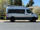 Silver Sprinter camper van, ideal for rv rental adventures, featuring bike rack & cargo carrier.
