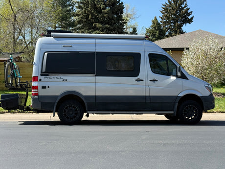 Silver Sprinter camper van, ideal for rv rental adventures, featuring bike rack & cargo carrier.