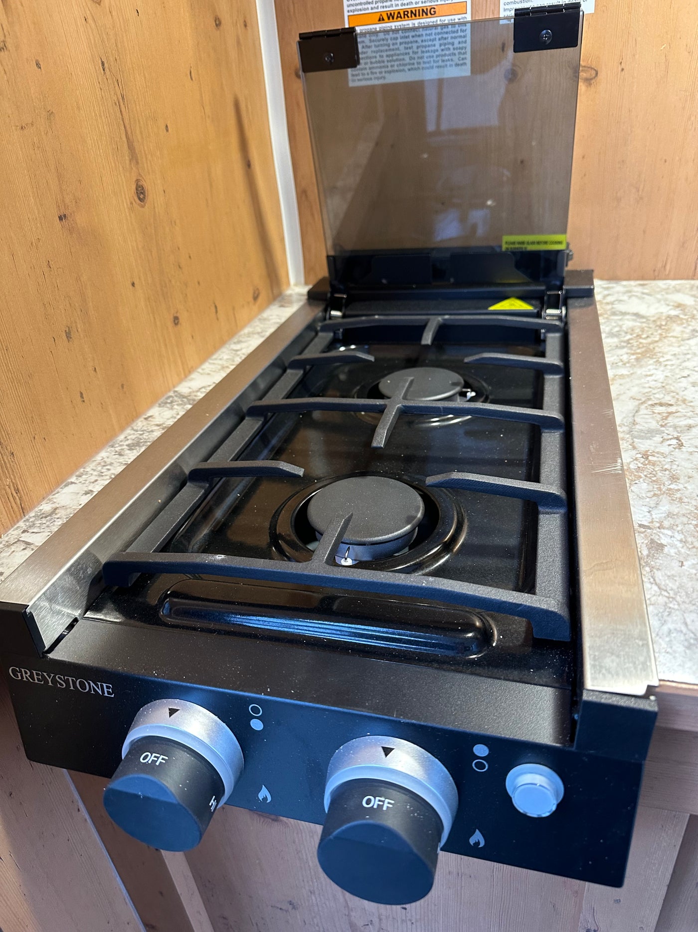 This RV rental kitchen features a clean Greystone two-burner cooktop, ready for your adventures. — photo 11